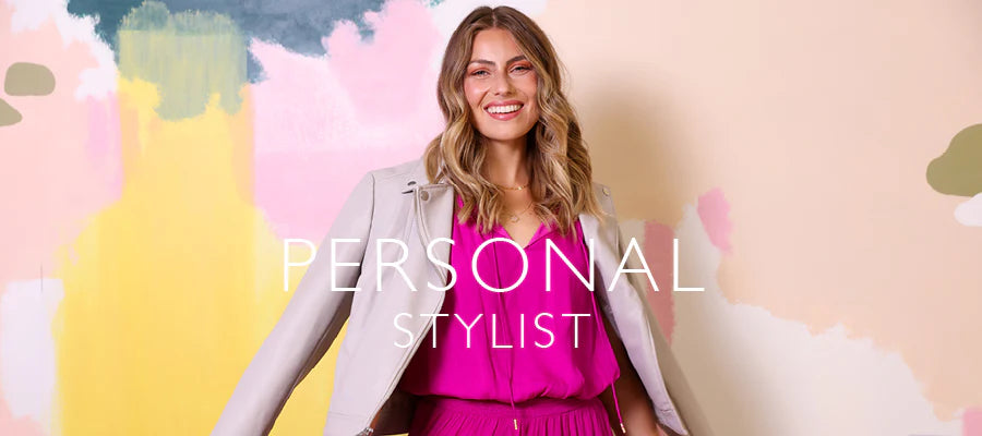 A smiling woman stands against a pastel abstract painted wall, wearing a bright pink outfit with a light gray blazer. Large white text across the center reads 'PERSONAL STYLIST'.